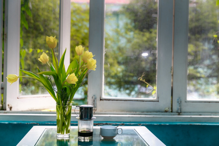 a flower vase beside the window