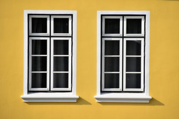 two windows on the yellow wall